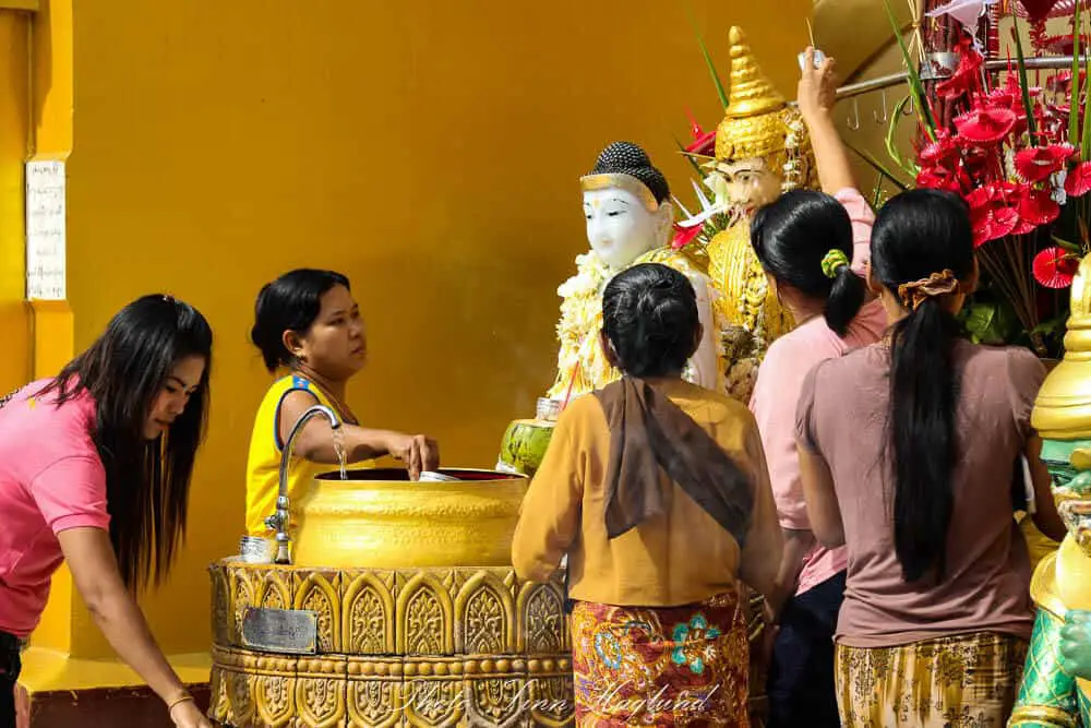 Women performing Buddhist rituals in a temple in Myanmar