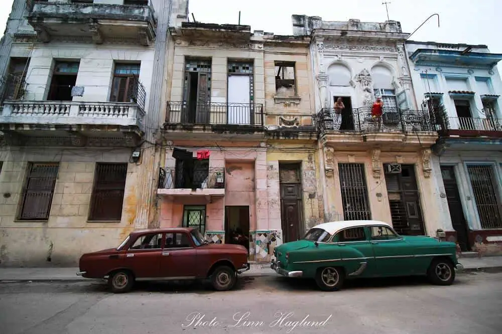 Cars parked in front of pastel colored houses in Havana