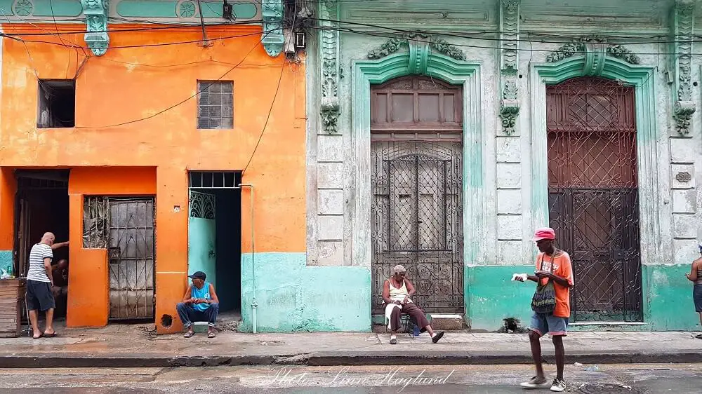 Daily life in Havana - people haning out in front of colorful houses. This is the real Cuba