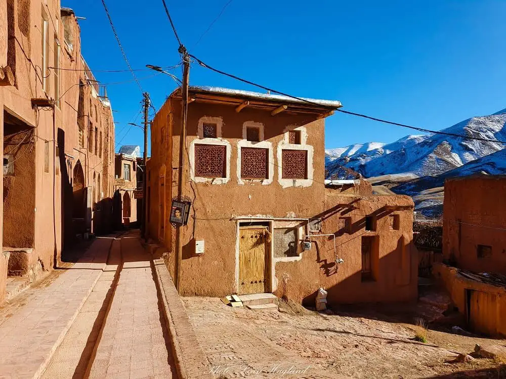 The red village of Abyaneh Iran with white-capped mountains behind