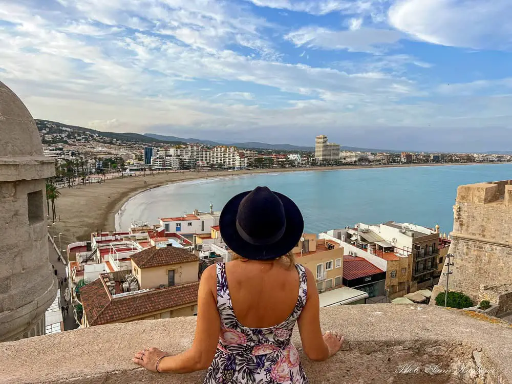 Me looking at the beach views from the old city walls in Peñiscola on a Spain road trip.