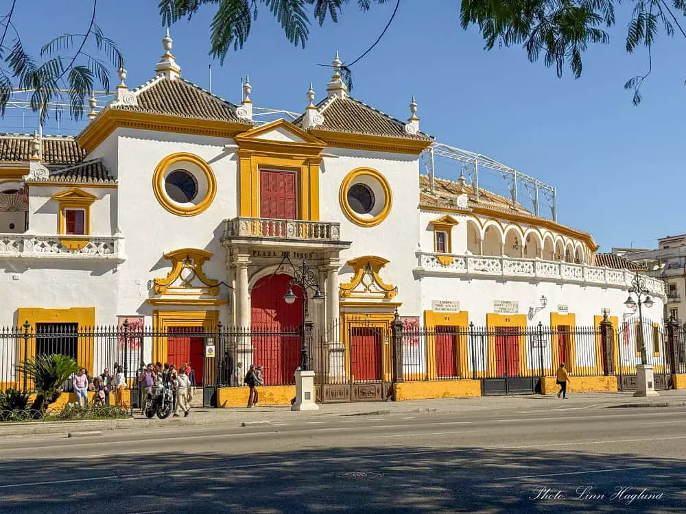 The round, white and yellow building housing Seville's bullring. Tourists are waiting outside to see the inside, not knowing that this is one of the most unethical things to do in Seville, as the money go to more bullfights.