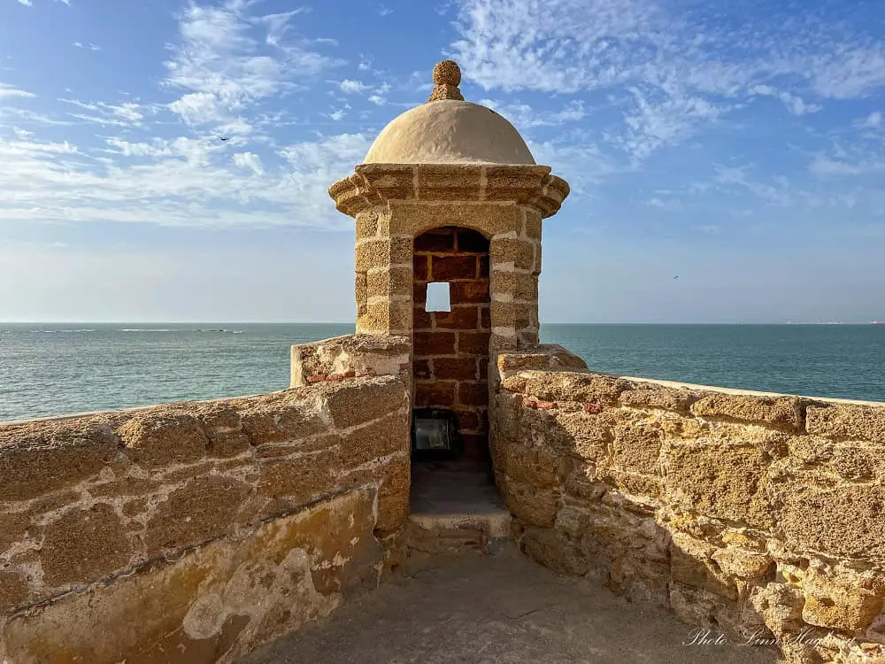 A watch tower at Santa Catalina Fortress in Cadiz Spain overlooking the sea. The watch post only has space for one person inside and has windows overlooking the seaside.