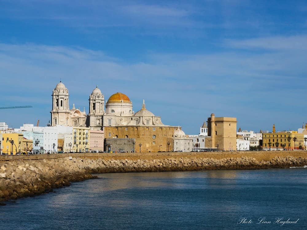 Cadiz Cathedral seen from the seaside promenade is the most iconic view of the city. The two clock towers and the golden dome dominate the view.