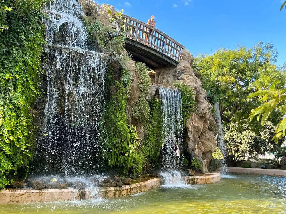 Me on a wooden bridge above a waterfall cascading into a pond in Genovés Park in Cadiz Spain. This is the biggest and most popular of the parks in Cadiz.