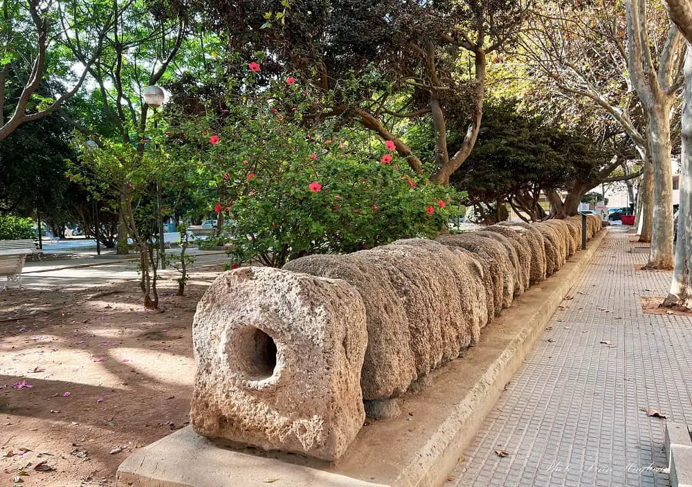 A long stone structure with a hole in the middle, which are the remains of one of the longest Roman aqueducts in Spain. It's laying in a public park in Cadiz in southern Spain with free access to the public.