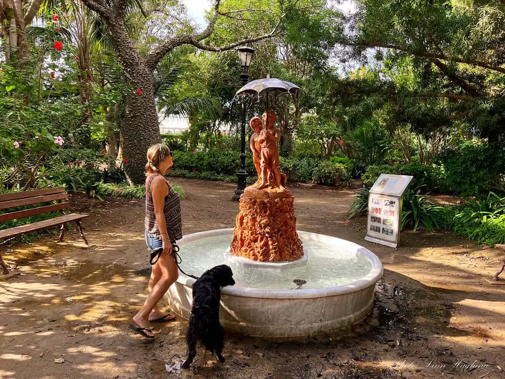 Me and Ayla looking at a fountain with a couple under an umbrella in the Genovés Park in Cadiz Spain. This is one of the best things to do near La Caleta Beach in Cadiz Spain.
