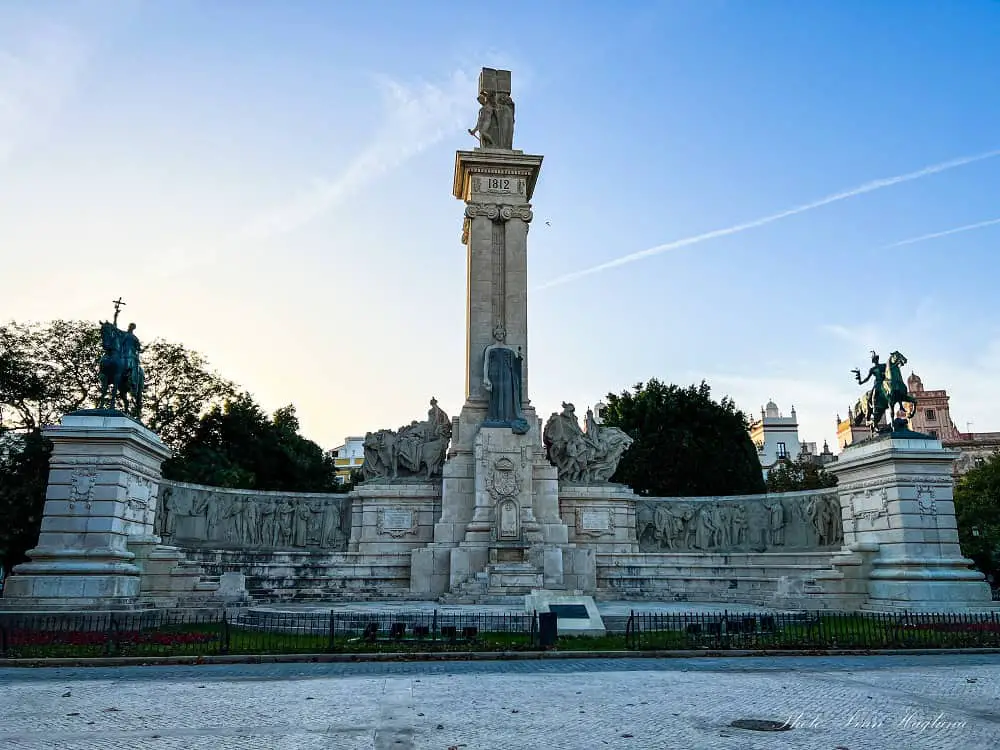 A large monument in Plaza de España Gardens in Cadiz Spain during sunset.
