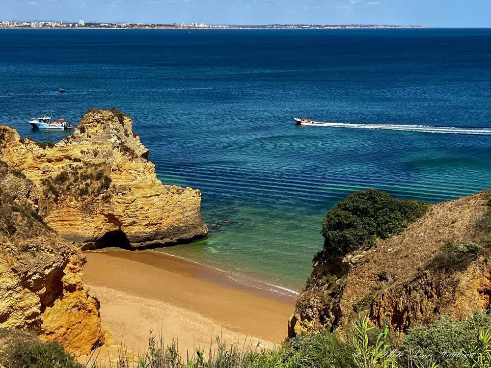 Boat tours in Lagos passing beautiful beaches and rugged cliffs.