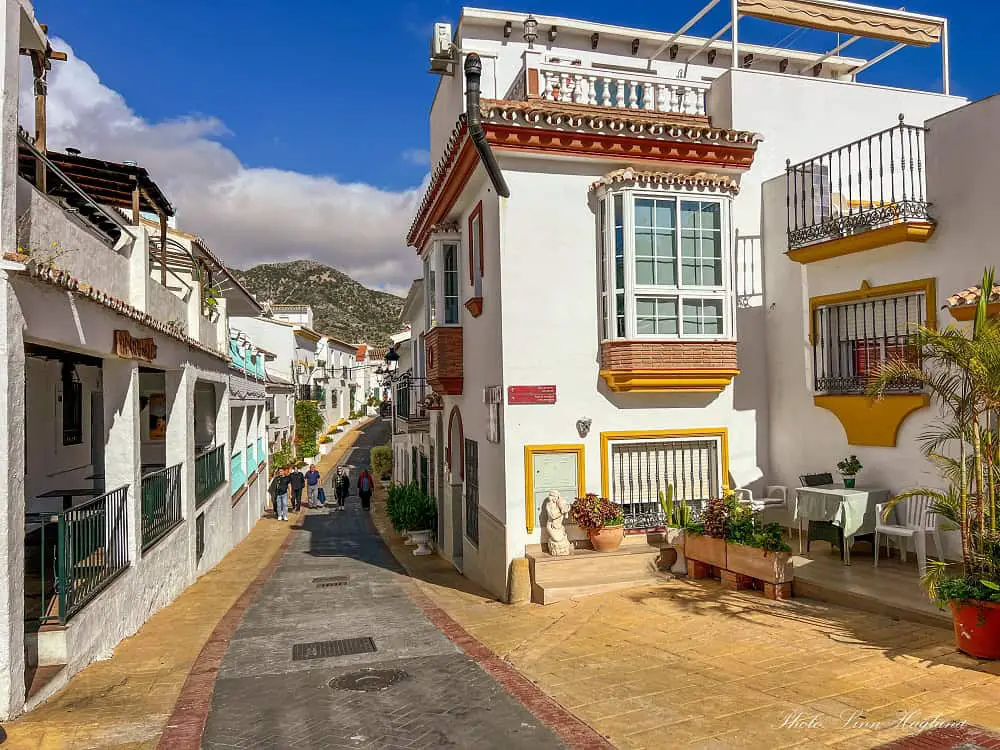 A cute street and whitewashed houses in Benalmadena Pueblo, one of the most beautiful Malaga towns on Costa del Sol.