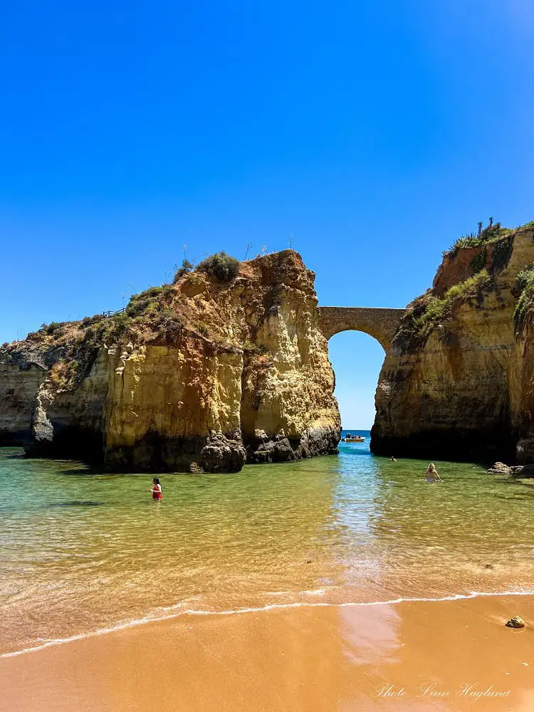 Two people swimming in Praia Etudiantes in Lagos in winter.