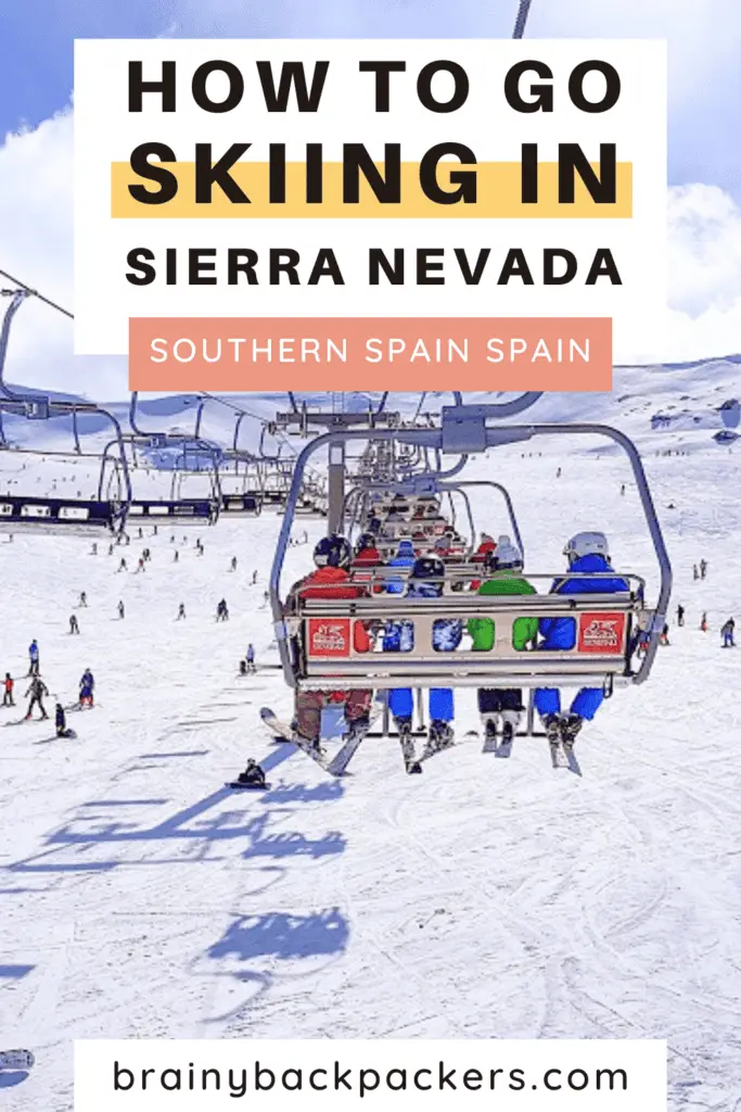 People sitting in a chairlift looking at people skiing in Sierra Nevada Spain.