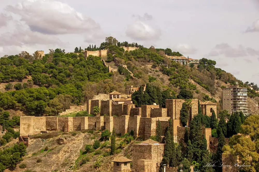 An old Moorish castle on a green hillside.