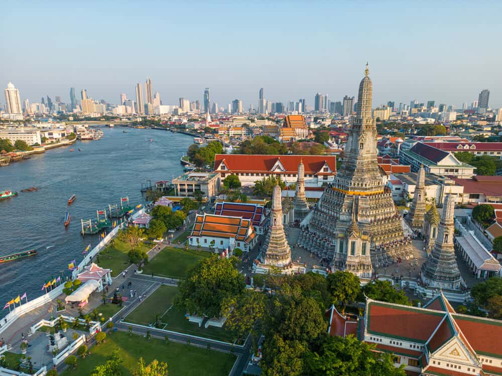 City view of Bangkok and the river with Wat Arun temple towering above the skyline.
