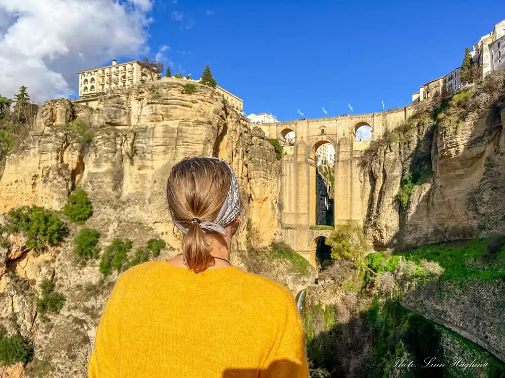 Me looking at a dramatic bridge connecting the two sides of Ronda which is perched atop to cliffsides, so if you wonder: Is Ronda worth visiting? the answer is yes!