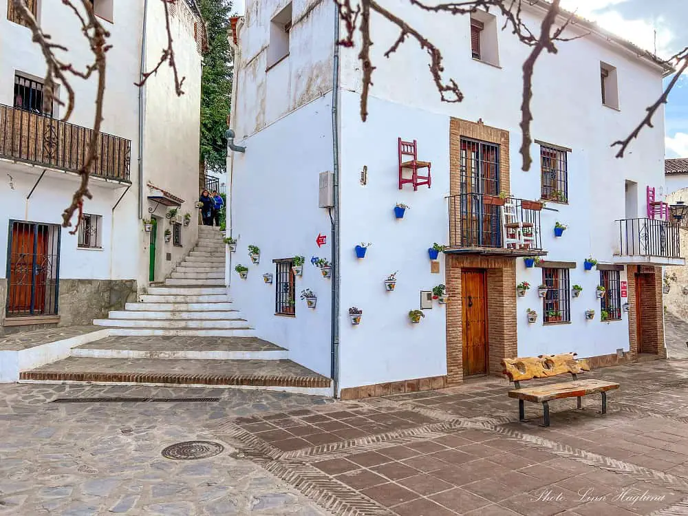 Decorated white houses with chairs and pot plants on the walls in Parauta, which is on the pretties white villages near Ronda, Spain.