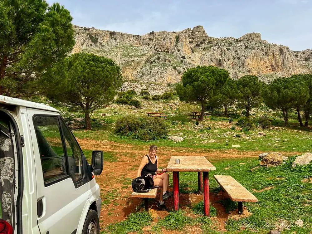 Campervanning in Spain: Our puppy Atlas and me sitting outside the van in natural environment with mountains behind us.
