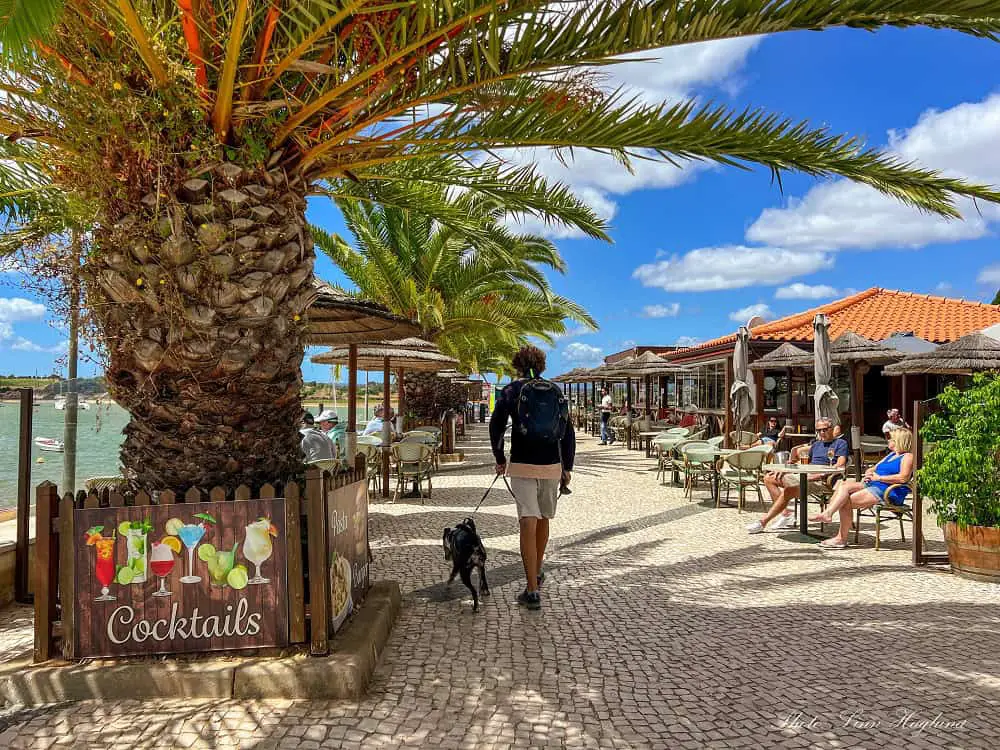 Mohammed and Atlas walking on Alvor Portugal promenade, past people having cold drinks in the bars along the promenade.