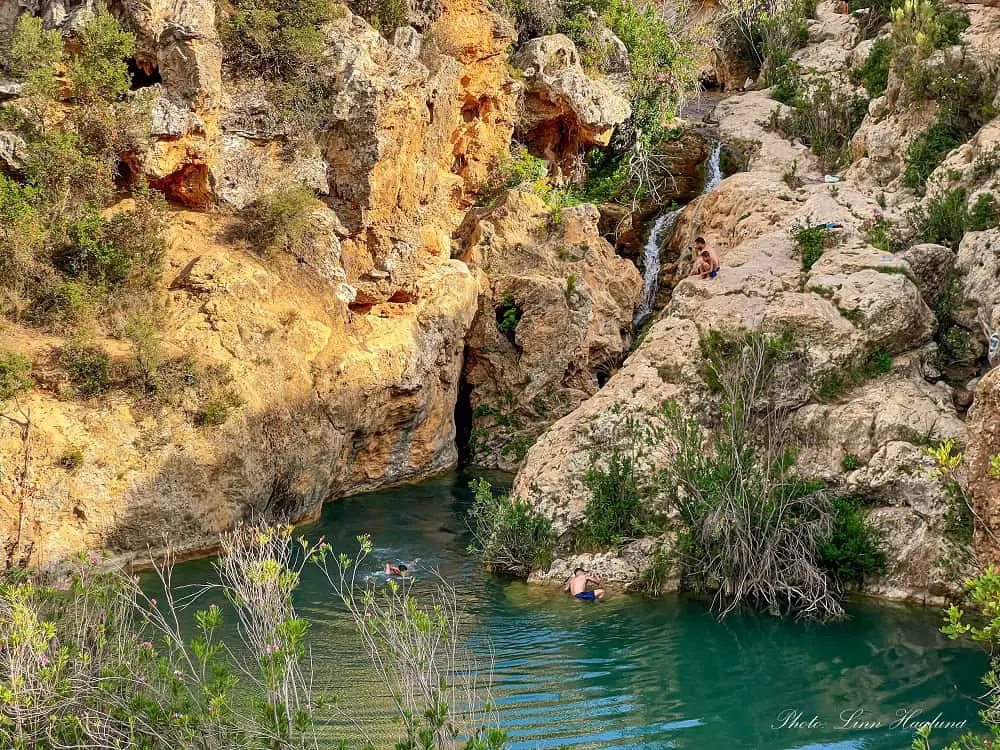 Kids swimming and cliff jumping in the swimming hole of Charco del Mañán Ruta del Agua Buñol Valencia Spain.
