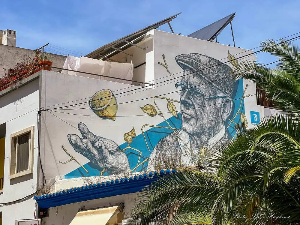 Street art Faro Portugal of an old man catching a lemon.