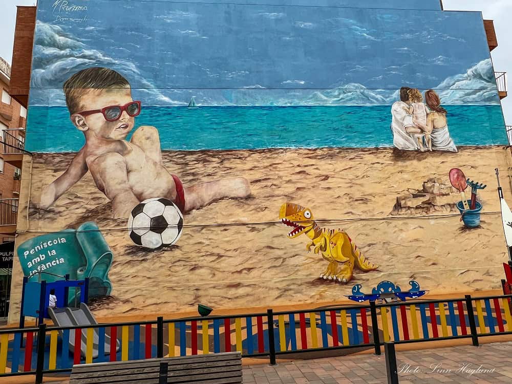 Street art of a boy playin gon the beach in Peñiscola Spain.