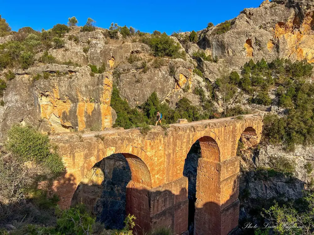 Me walking across a large aqueduct in nature on one of the most astounding Valencia hiking trails.