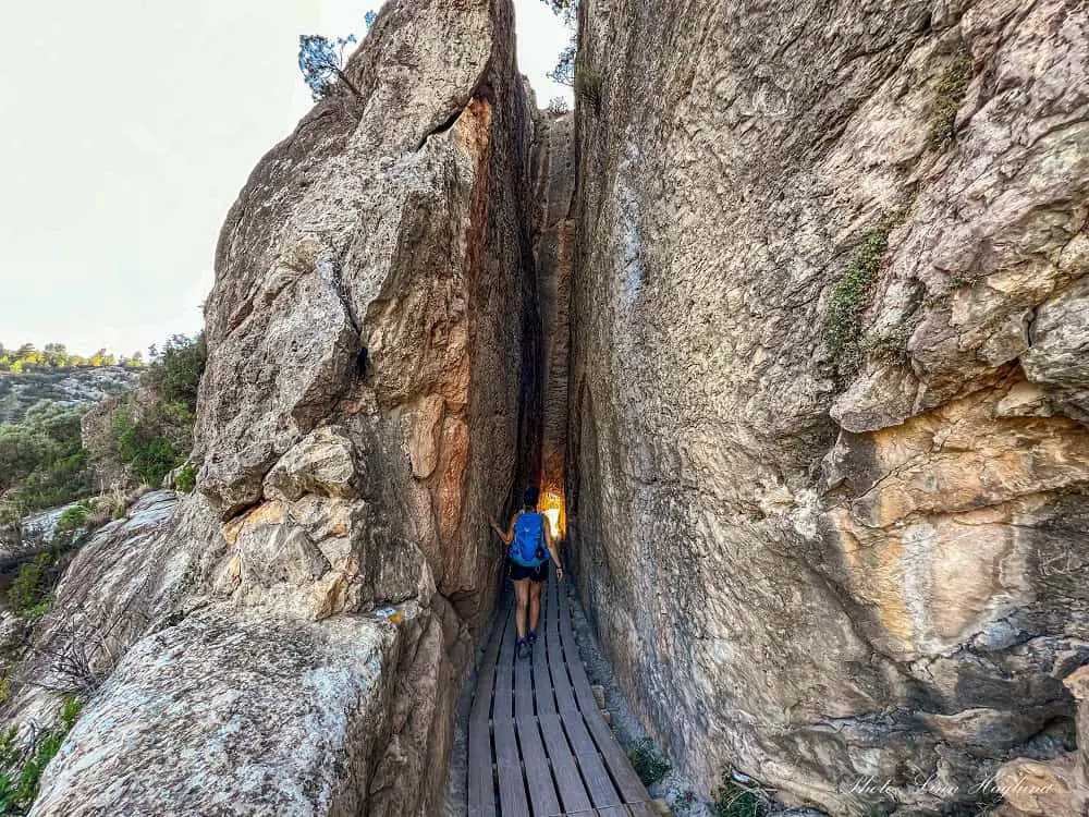 Me hiking through a tunnel with tall walls on the sides.