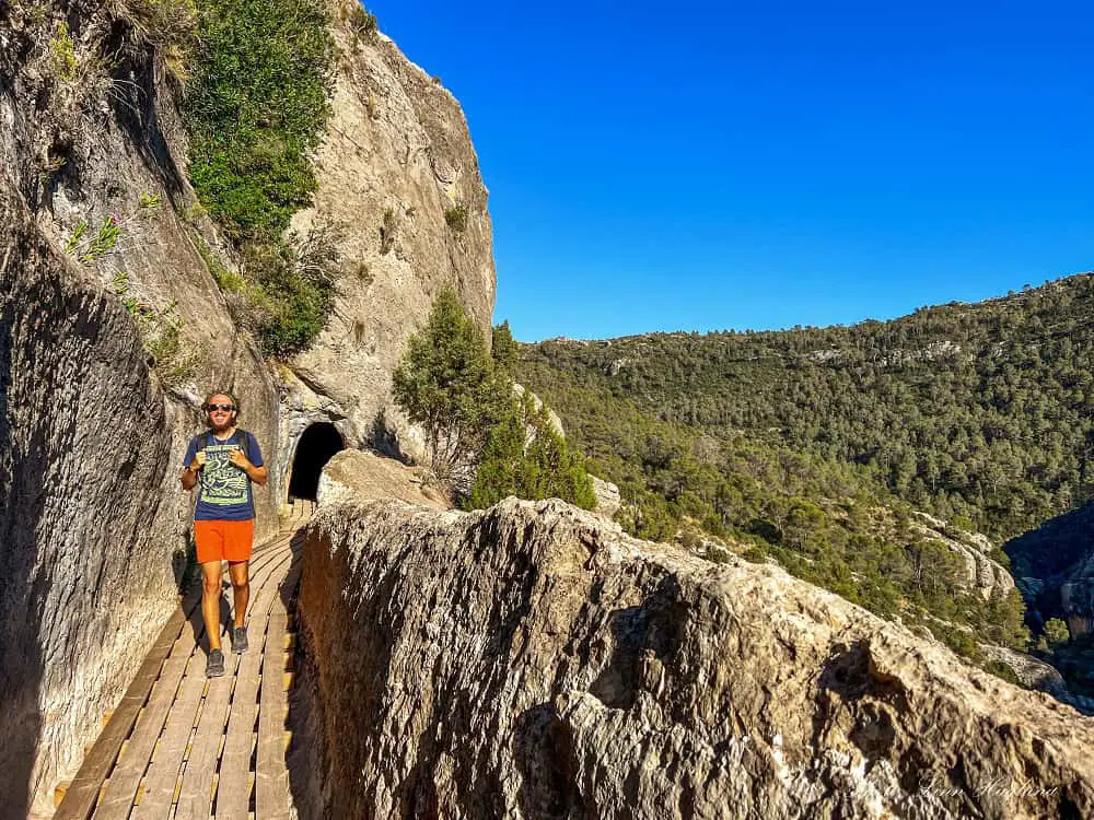 Mohammed hiking between tunnels and with sweeping views on the side of the mountain.