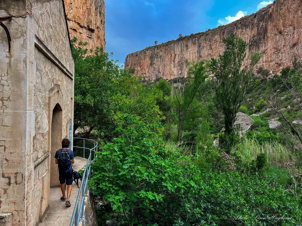 Mohammed walking on a suspended trail along a power station in Turia Gorge.