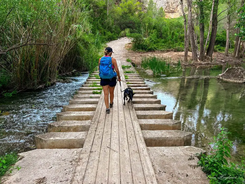 Me and Atlas walk to Charco Azul Chulilla across a wooden walkway in the river.