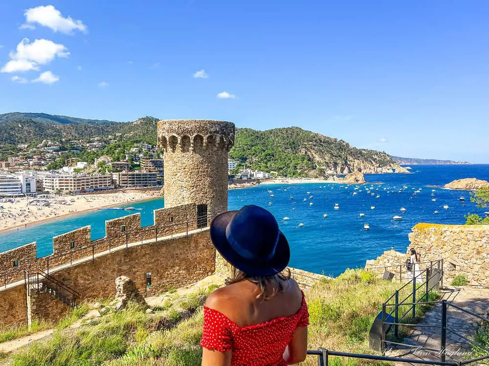 Me looking at the views of the old city walls and tower with the blue sea in the background in Tossa de Mar.