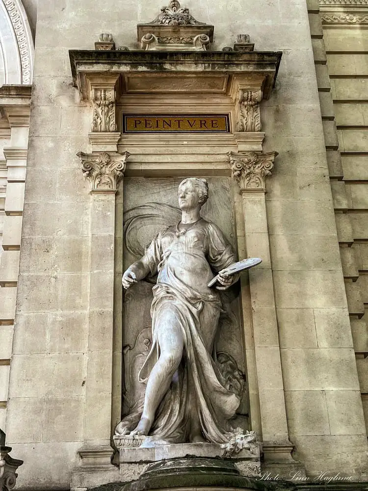 statue of a woman on a wall - what to do in Nimes old town.