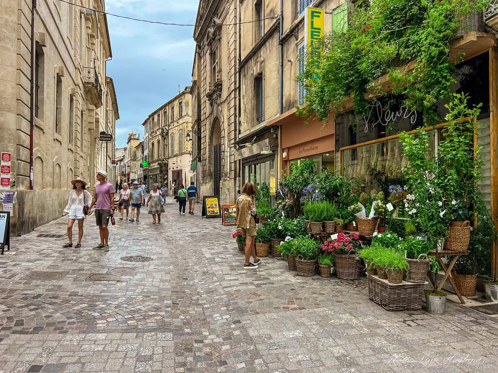 People walking in the cobblestoned streets in the old town of Arles France.