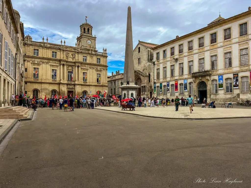 Crowds of people visit Place de la Republiquer on a day in Arles France.