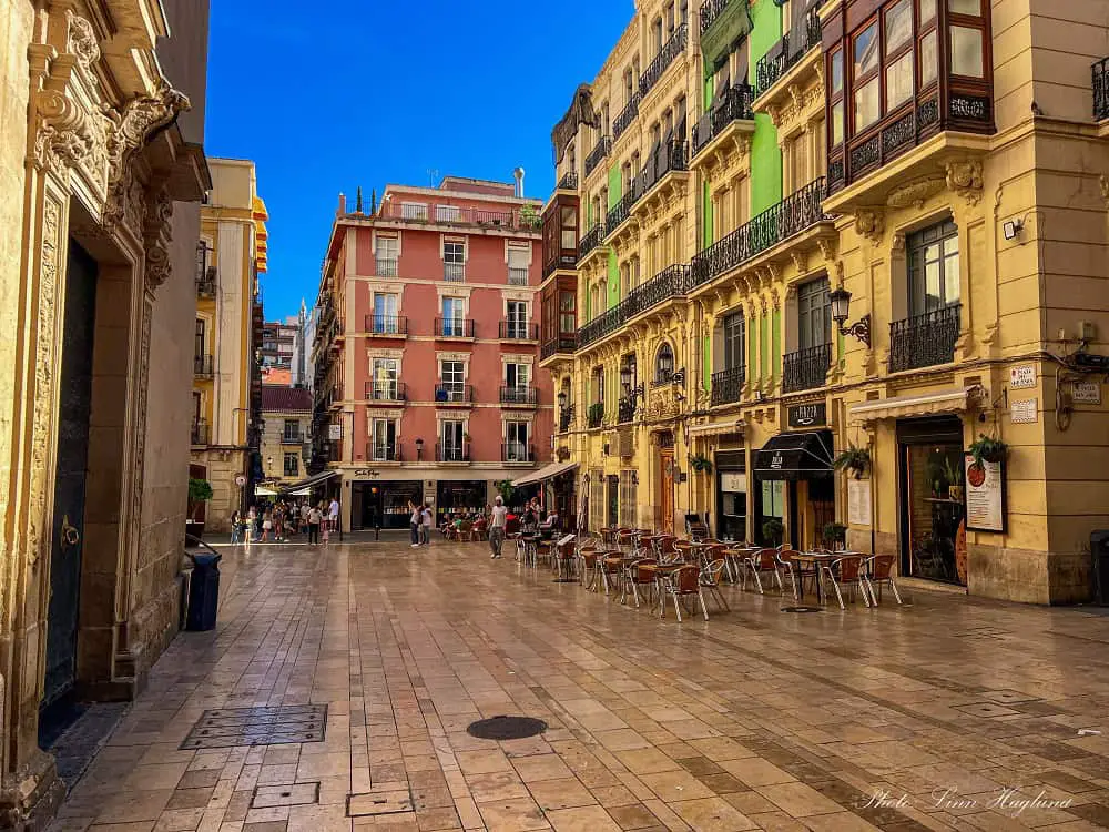 A beautiful square in Alicante Old Town with pastel colored buildings and cafés.