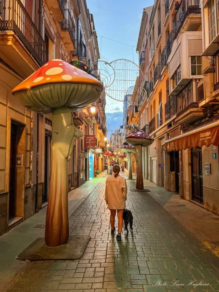 Me and Atlas walking beside a giant mushroom in Mushroom Street an an Alicante day trip.