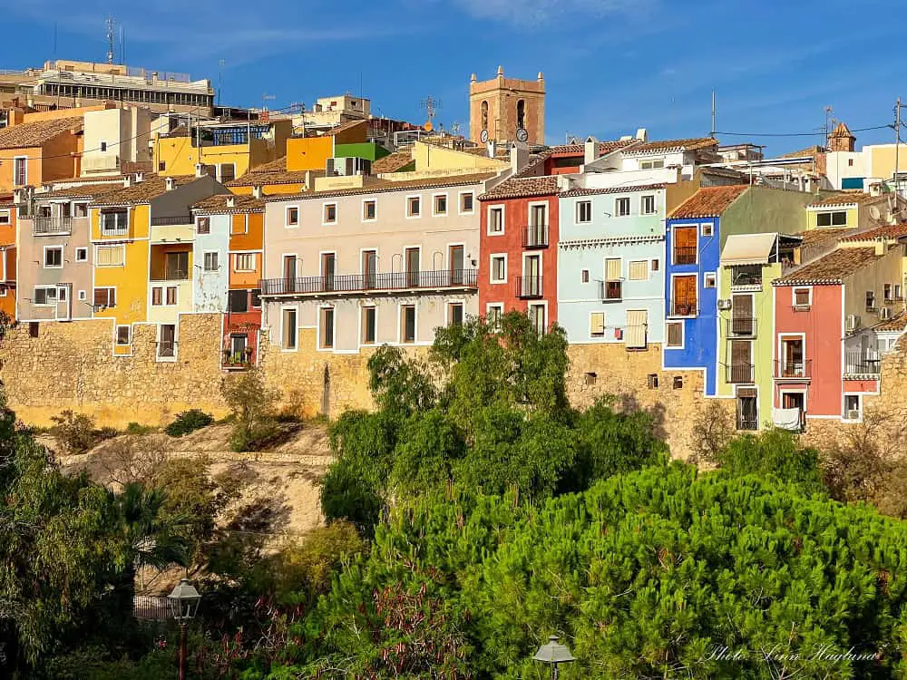 Villajoyosa city walls with colorful houses on top.