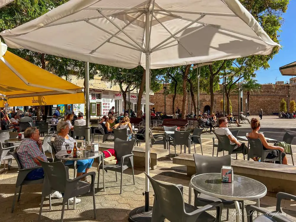 People enjoying the sun at outdoor tables of a Bar in Santa Pola.