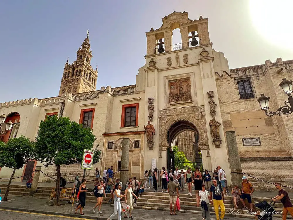 Seville Cathedral with people walking in the front of it.