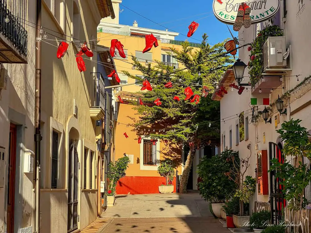 Red shoes hanging across a street in Calpe Old Town.