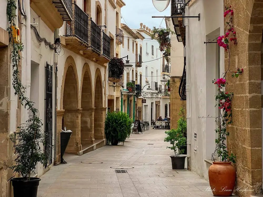A narrow street with medieval buildings and porticos in Javea Town Costa Blanca.