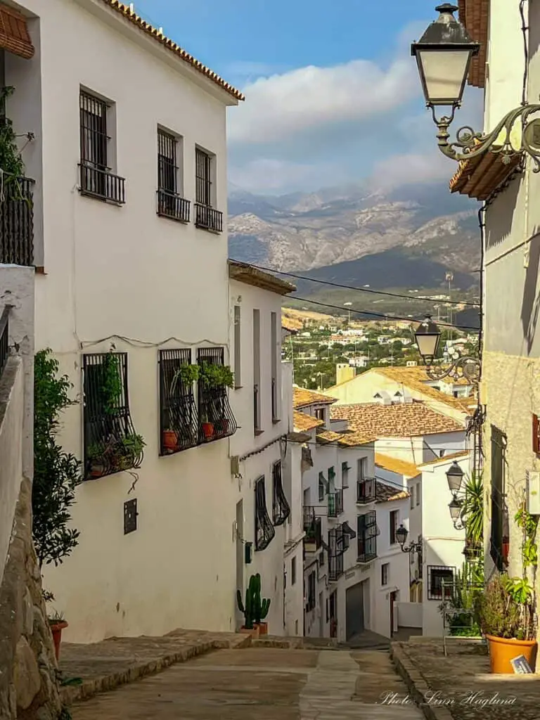 Narrow, steep street in Altea Spain with views of the mountains.
