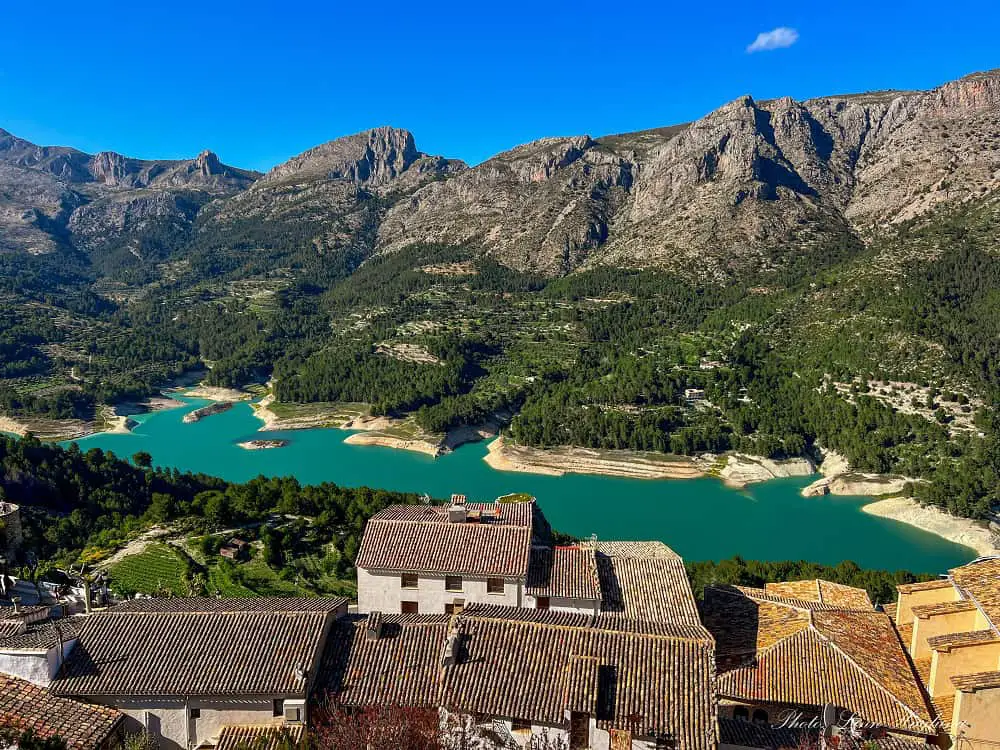 Views of Guadalest Reservoir surrounded by pine tree covered mountains, seen from Guadalest Castle.