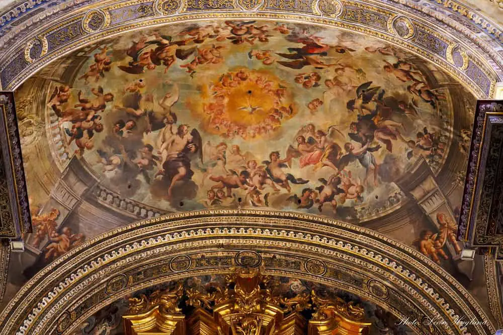 A colorful frescoed dome in the Collegiate Church of the Divine Savior in Seville Spain, depicting multiple angels. This church is included in the seville Cathedral ticket and is one of the most beautiful things to see in Seville.