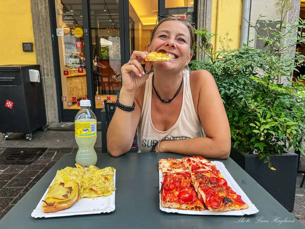 Me eating Roman pizza all'taglio with potato and tomato in Como Italy. This is a must-try place to eat on a budget if you spend one day in Como city.