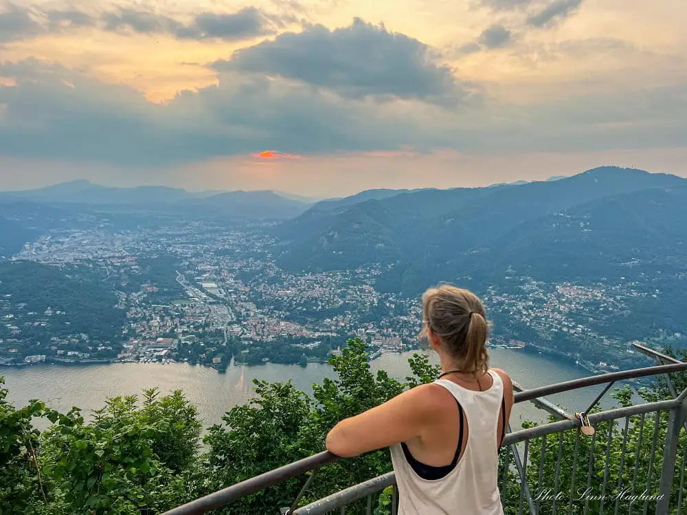 Me looking at the sunset from Faro Volitano viewpoint in Lake Como Italy. On the other side of the lake, you can see Cernobbio, one of the prettiest towns in Lake Como.