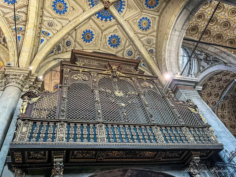 Organ with beautiful details under a colorful ceiling with blue and golden details in Como Cathedral. Visiting the cathedral is one of the best things to do in Como city in one day.