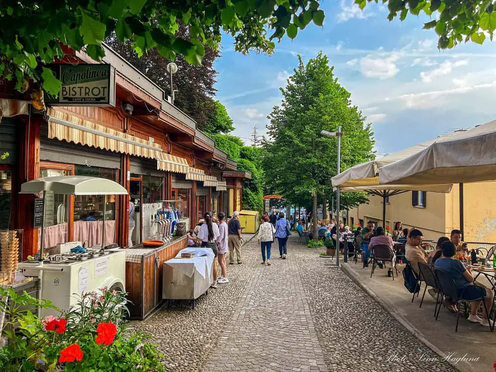 People eating and drinking in restaurants and bars with lake views in Brunate Italy. This is one of the most popular things to do in Brunate to enjoy the views of Lake Como.